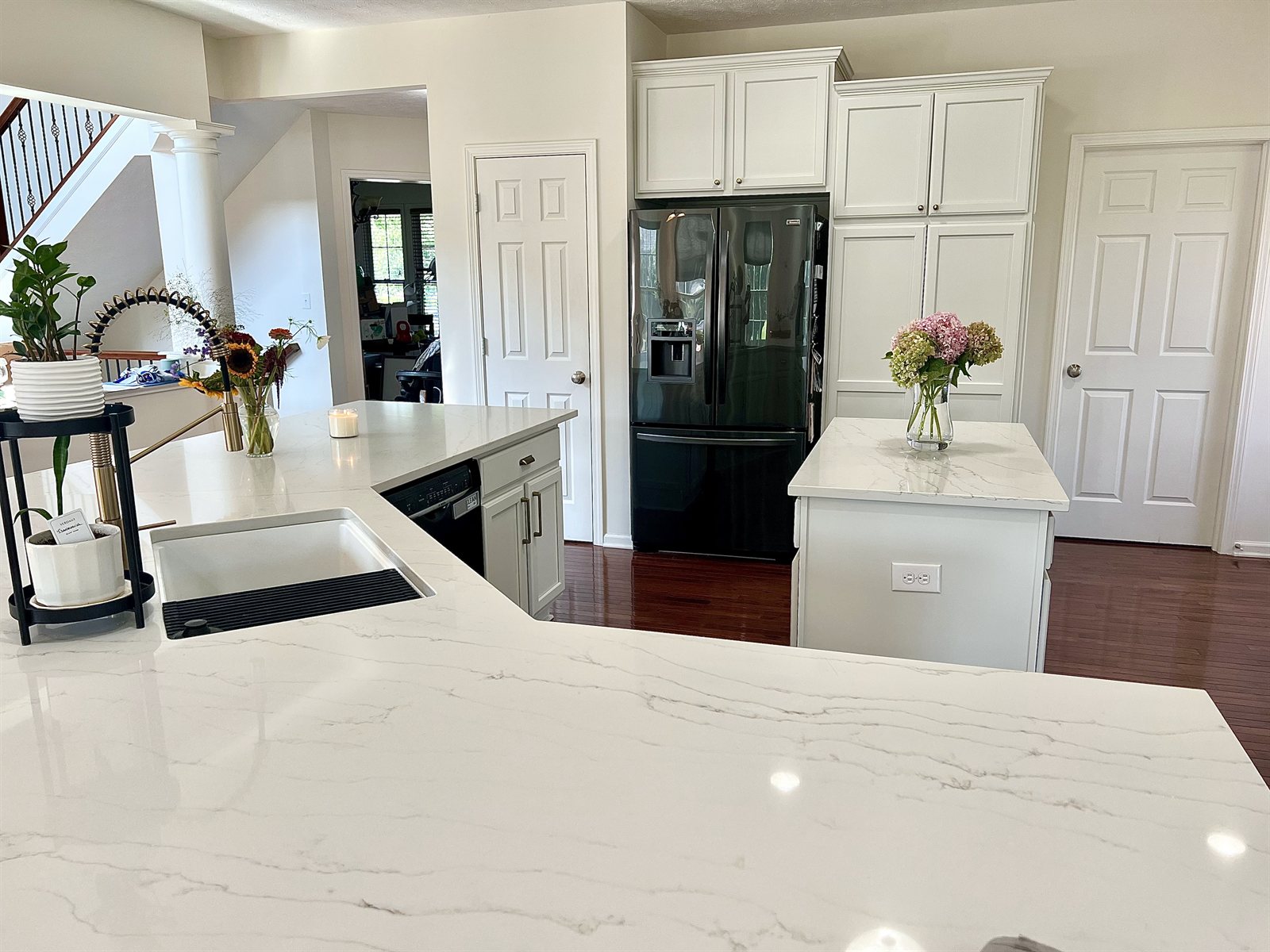 White kitchen wide view with island and fridge